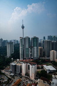 Buildings in city against cloudy sky