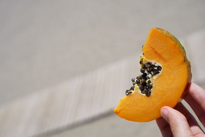 Cropped image of hand holding orange