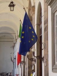 Low angle view of flags hanging on building