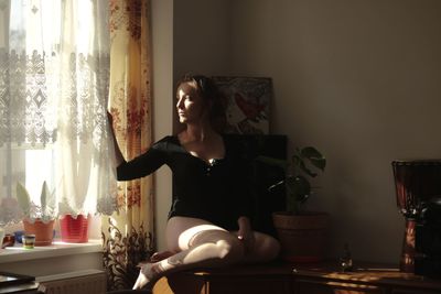 Woman sitting on table at home