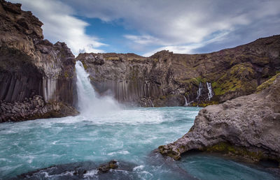 Scenic view of waterfall against rocks