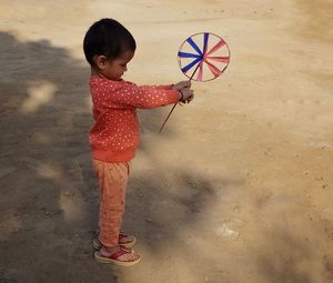 Cute girl playing with umbrella standing outdoors