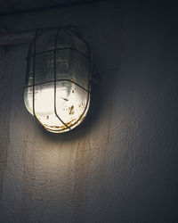 Low angle view of light bulb hanging on wall