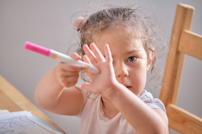 Little girl playing with invisible ink and coloring book