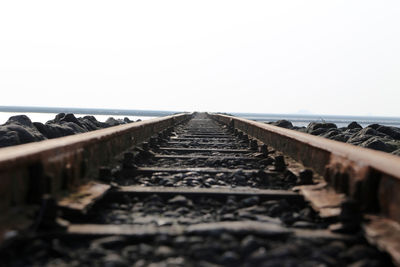 Surface level of railroad tracks against clear sky