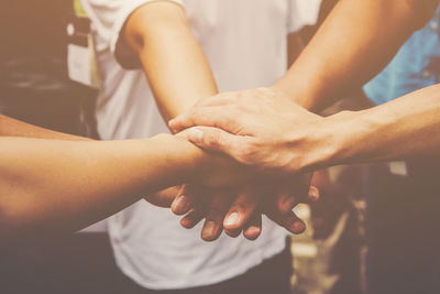 Midsection of friends stacking hands