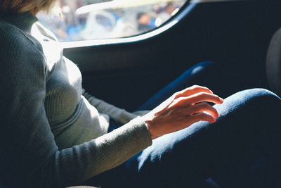 Side view of woman sitting in car