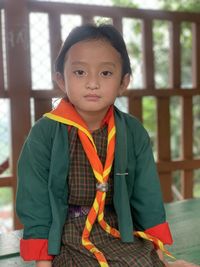 Portrait of smiling young woman standing against wall