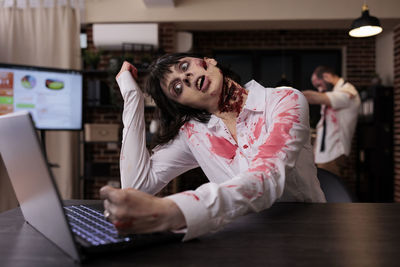 Young woman using laptop at table