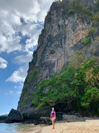 Woman walking at beach against mountain