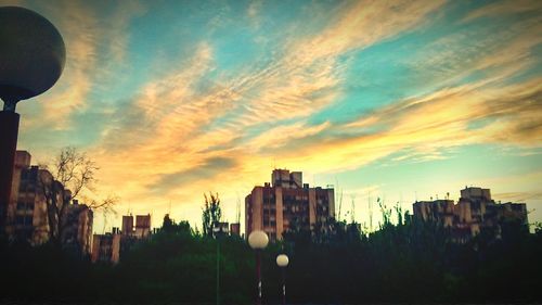 Buildings against cloudy sky at sunset