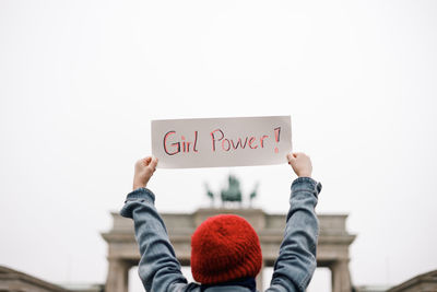 Low section of woman holding text against white background