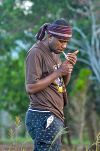 Young man using mobile phone while standing outdoors