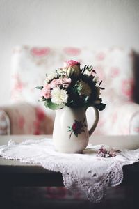 Close-up of flowers in vase with floral pattern on table at home