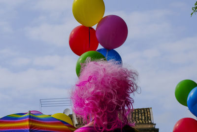 Rear view of woman wearing wig by colorful balloons