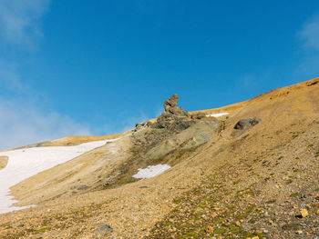 Low angle view of mountain against blue sky