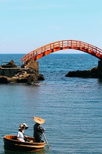 People on bridge against clear sky