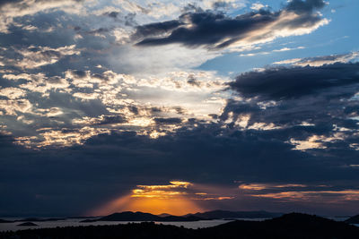 Scenic view of dramatic sky over silhouette landscape