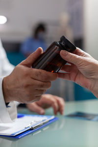 Cropped hand of doctor giving medicine to patient