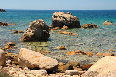 Rocks on sea shore against sky