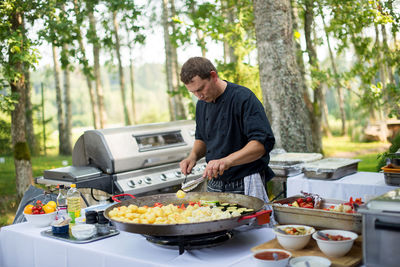 Man preparing food against trees