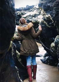 Rear view of friends standing on rock