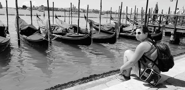 Woman sitting on boat moored in canal