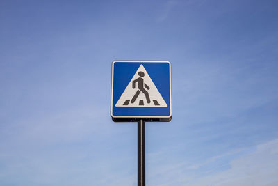 Low angle view of road sign against blue sky