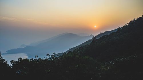 Scenic view of mountains against sky at sunset