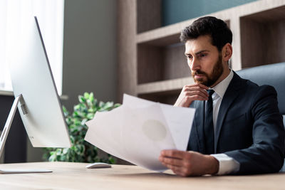 Side view of businessman using laptop at home