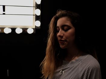 Beautiful woman with illuminated lights against black background