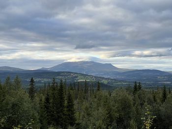 Scenic view of mountains against cloudy sky