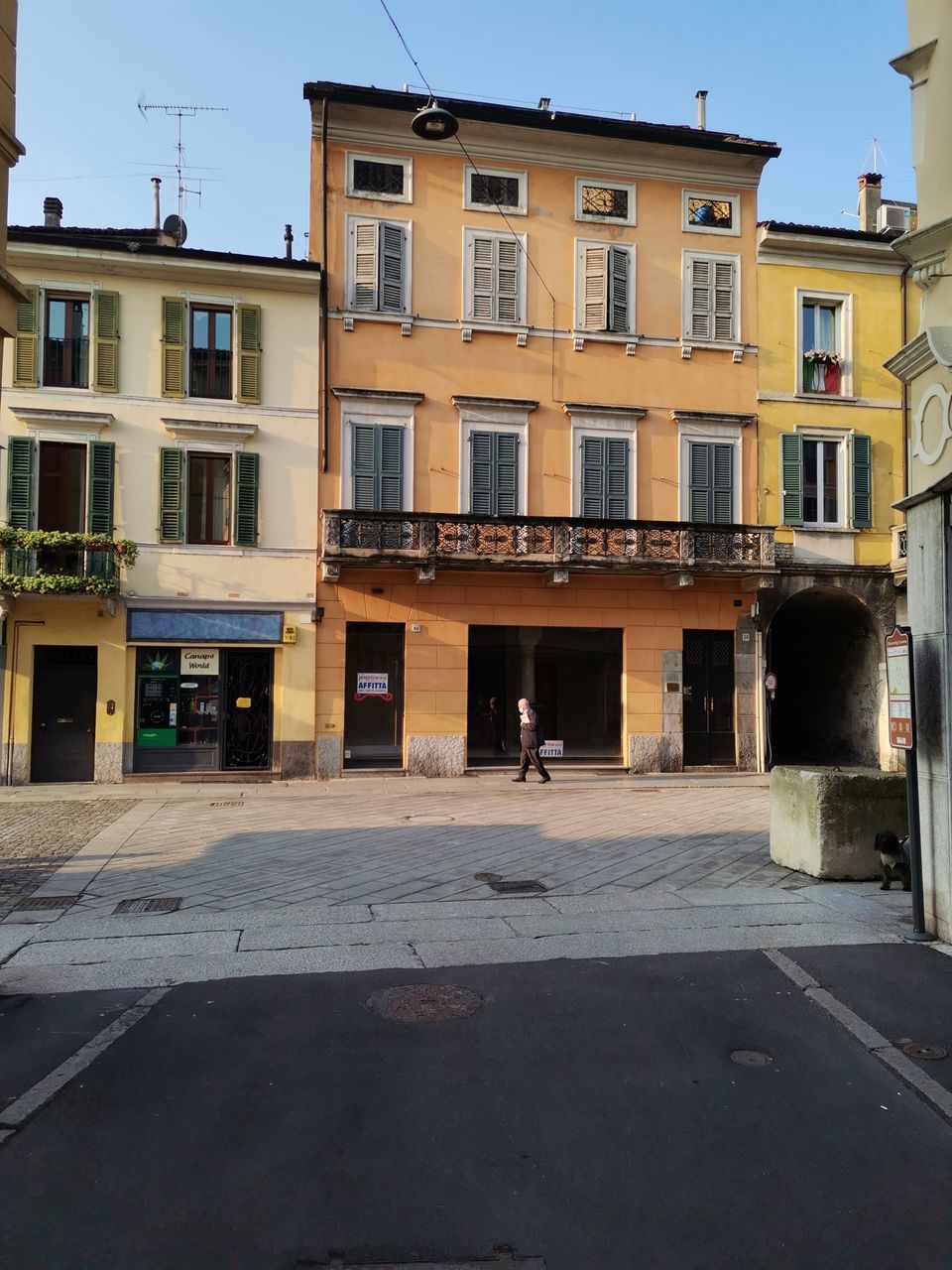 MAN WALKING ON STREET AGAINST BUILDINGS IN CITY