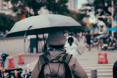 Rear view of woman with umbrella in rain