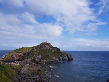 Rock formations by sea against sky