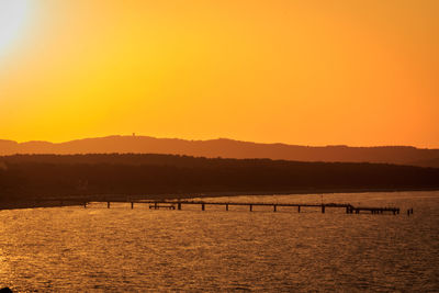 Scenic view of sea against orange sky