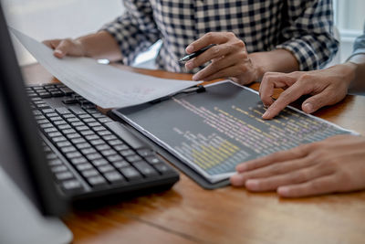 Midsection of man using laptop on table