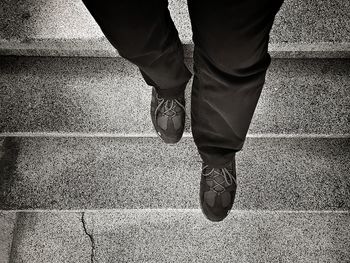 Low section of man moving down steps