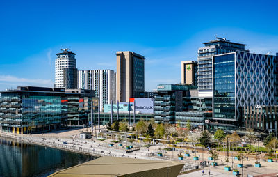 Modern buildings in city against blue sky