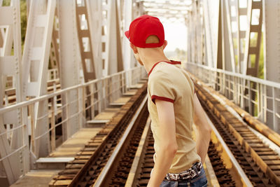 Rear view of teenage boy standing at railway bridge