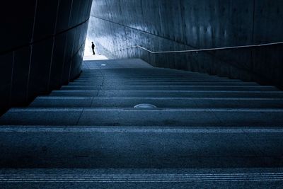 Silhouette of person walking on stairs at night