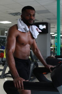 Athlete looking away while exercising on treadmill in gym