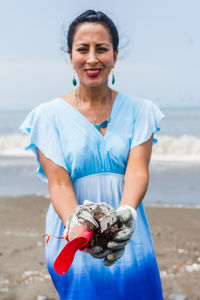 Woman on the beach holding garbage in her hands. concept of environmental pollution