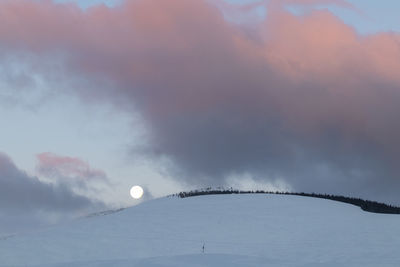 Low angle view of snowcapped mountain against sky during sunrise