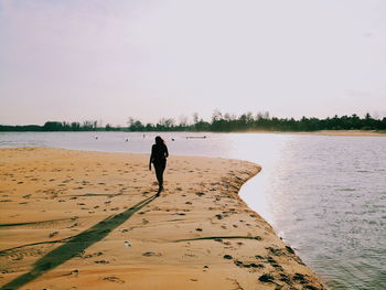 Man standing on beach against sky