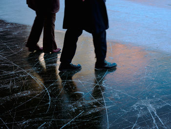 Low section of people standing on wet street