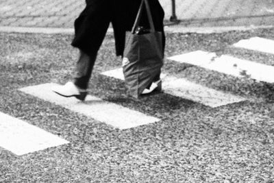 Low section of man crossing road