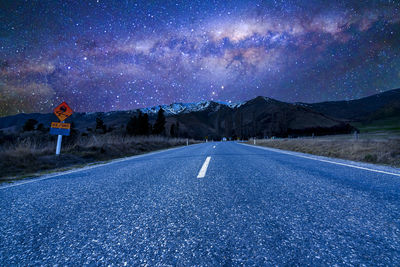 Empty road against sky at night