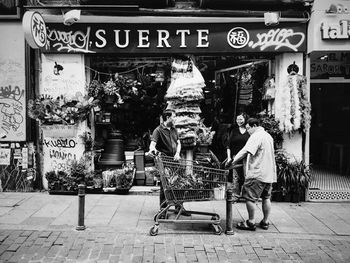 Side view of man sitting on sidewalk