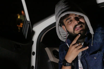 Man looking away while gesturing in car